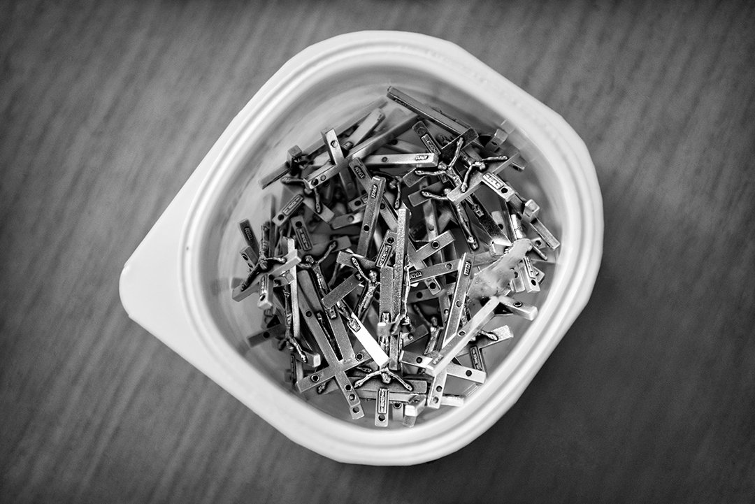 A container filled with small crucifixes.